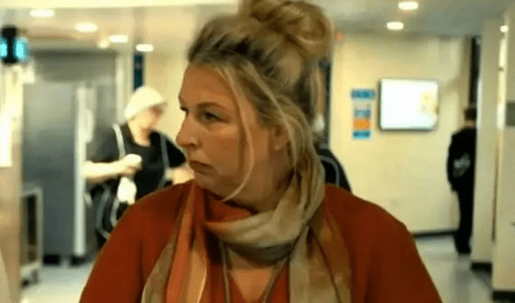 Woman in a red shirt and scarf looking to the side.