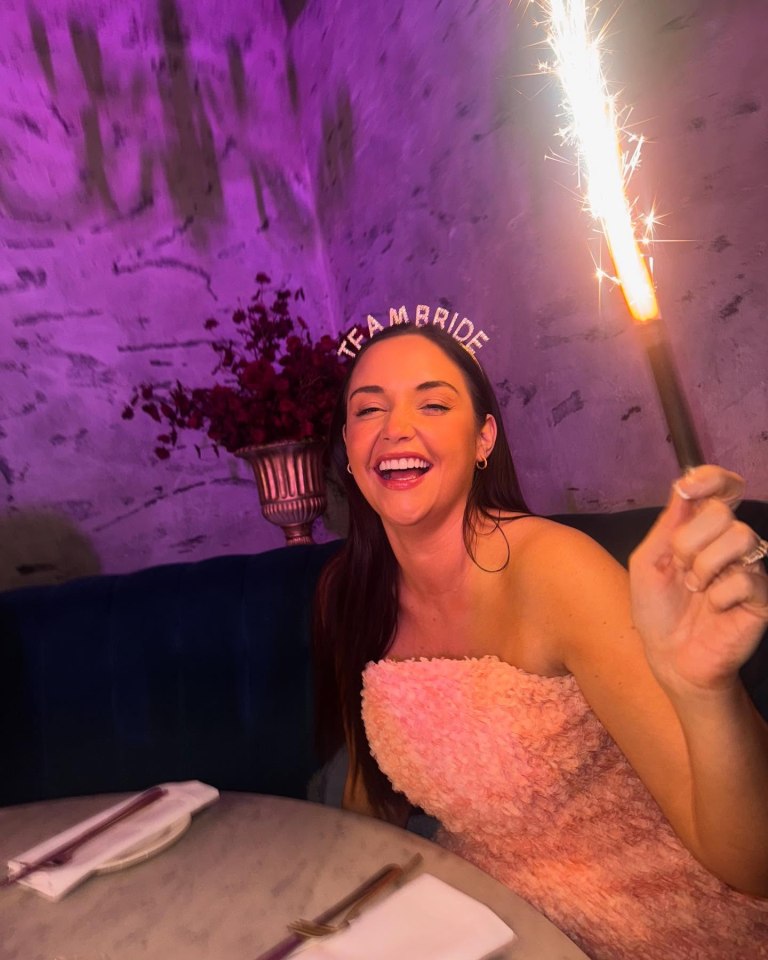 Woman at hen party holding sparkler.