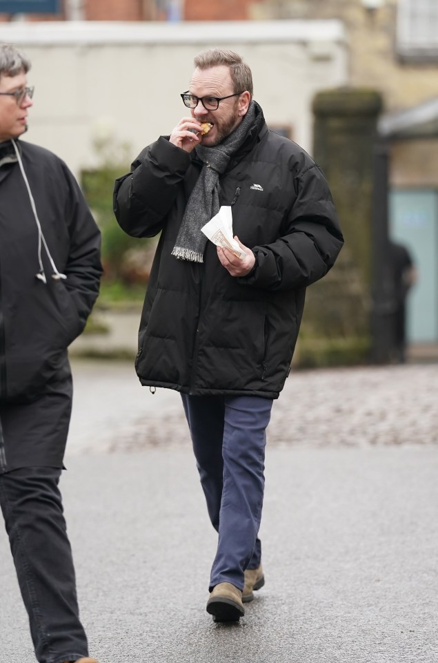Kiefer Sutherland eating a pasty while filming a movie.
