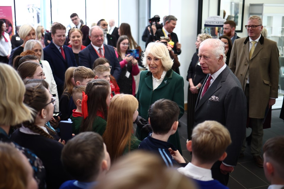 King Charles III and Queen Camilla speaking with schoolchildren.