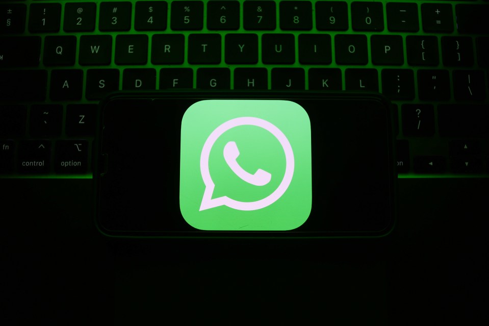 Illustration of a smartphone displaying the WhatsApp icon on a laptop keyboard.