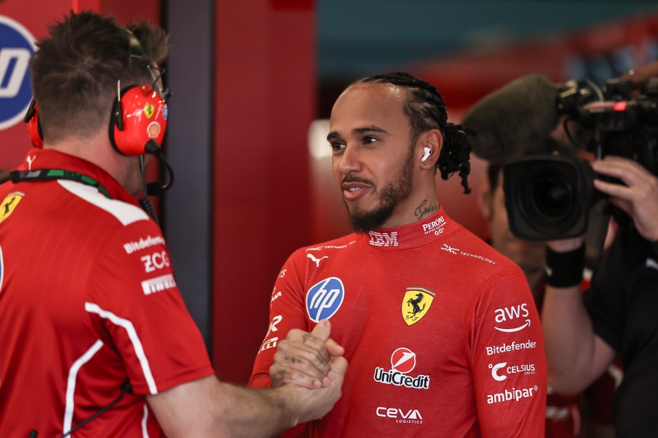 Lewis Hamilton shaking hands with a Ferrari mechanic.