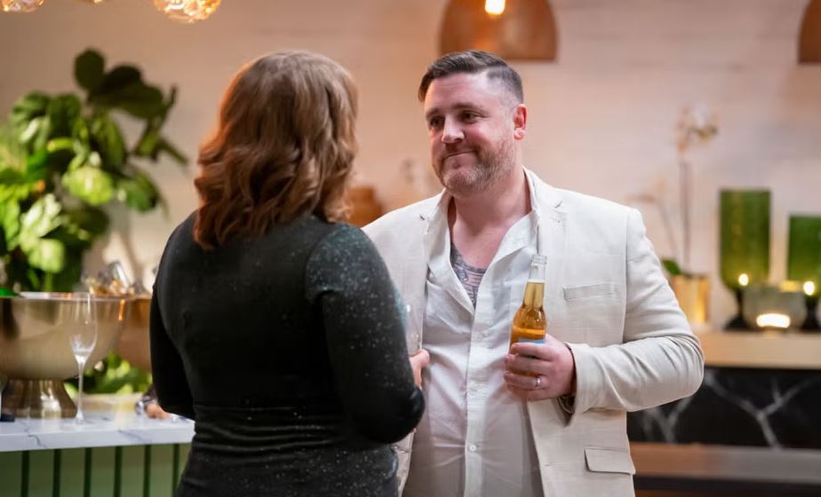A man and woman talking at a bar.