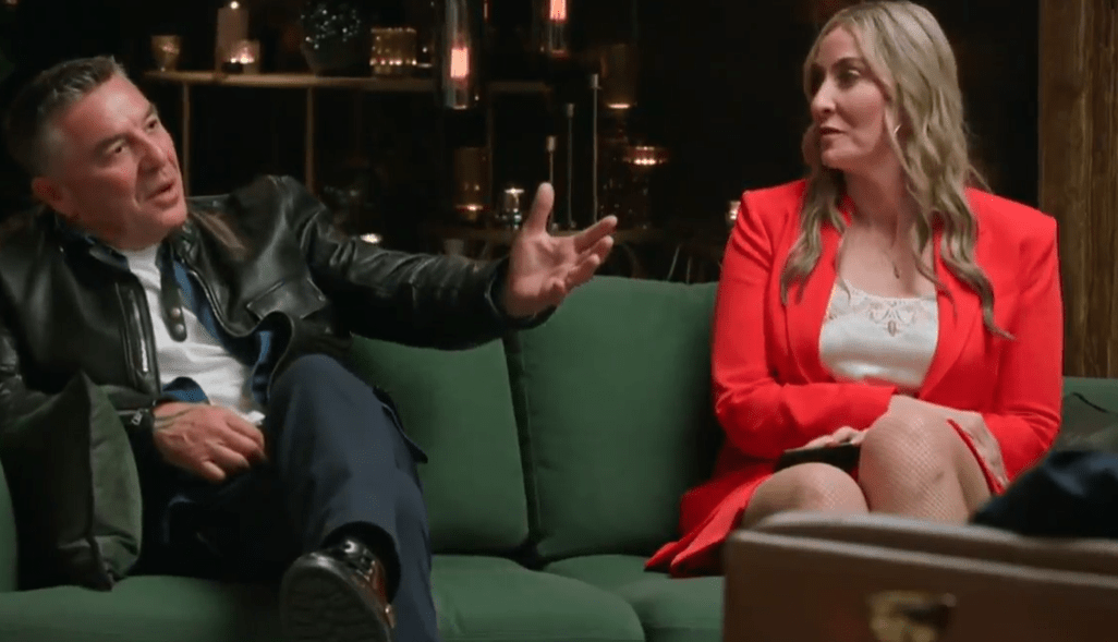 A man and woman sitting on a couch, talking.