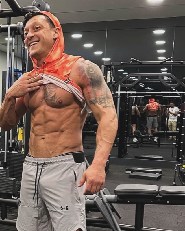 Mesut Ozil showing off his physique in a gym.