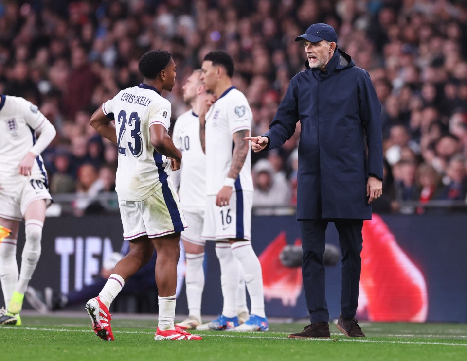 Thomas Tuchel coaching Myles Lewis-Skelly on a soccer field.