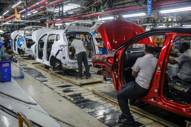 An image collage containing 1 images, Image 1 shows Workers assembling cars on a production line