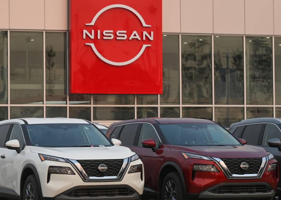 Nissan SUVs parked in front of a Nissan dealership.