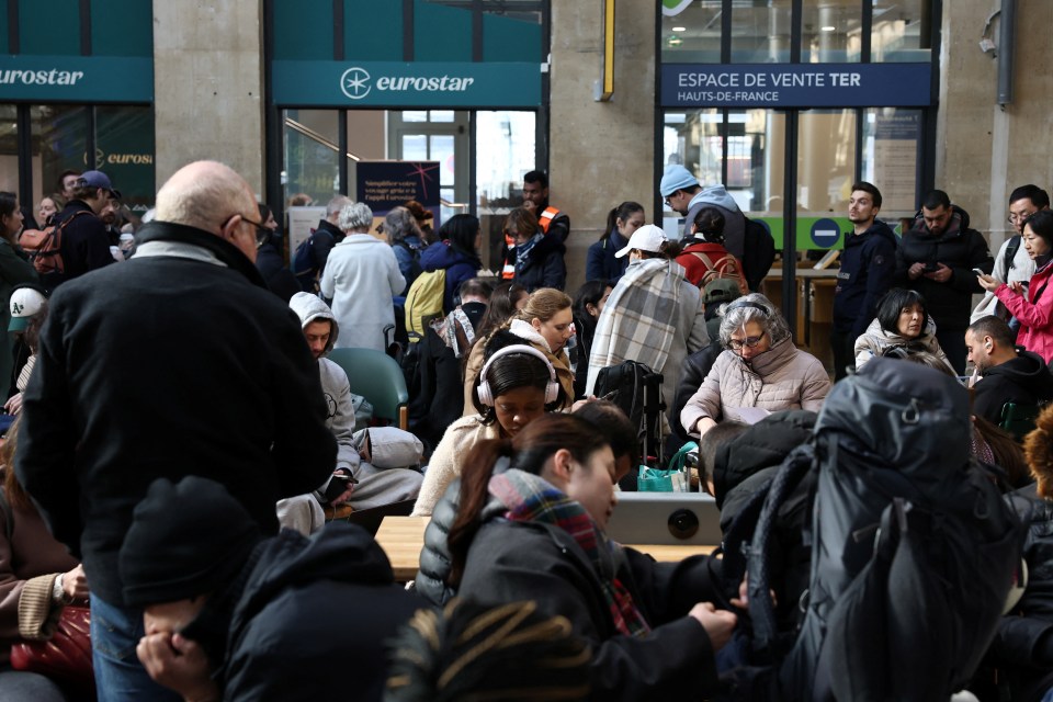 Passengers waiting in a train station departure hall.