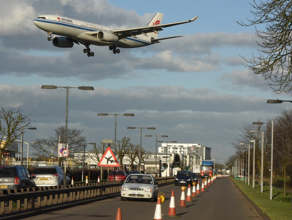 Air China Airbus landing over Heathrow perimeter road.