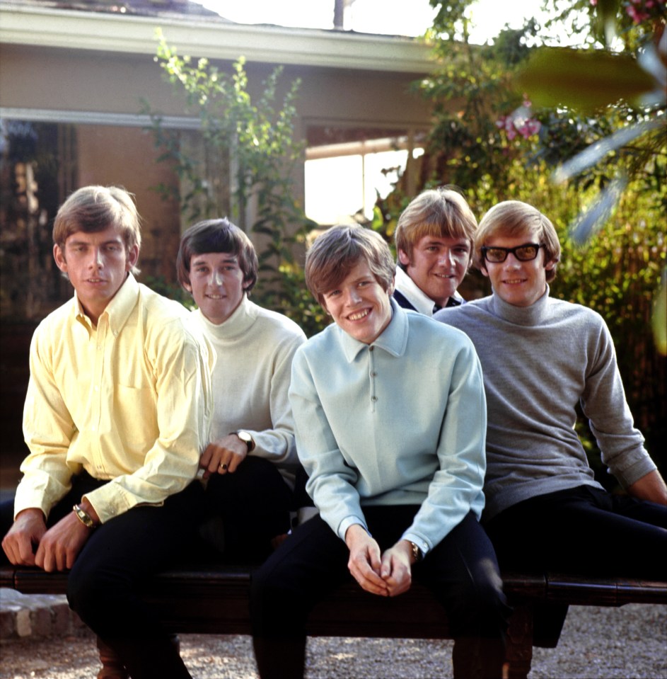 Black and white photo of Herman's Hermits with singer Peter Noone enjoying champagne and a cigar.