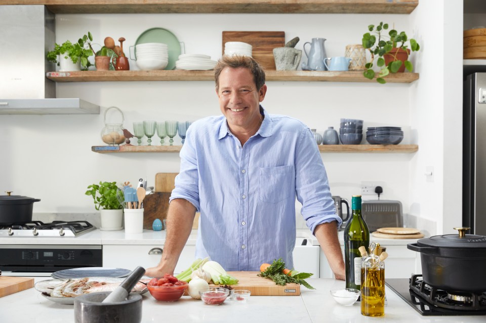 Chef standing in a kitchen with ingredients.
