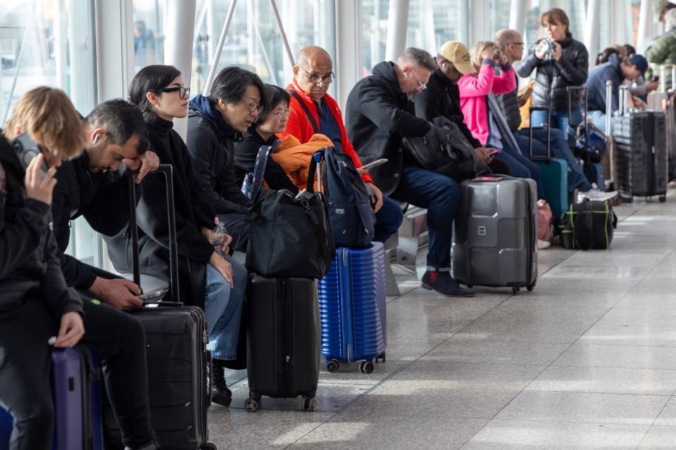 Passengers waiting at an airport with luggage.