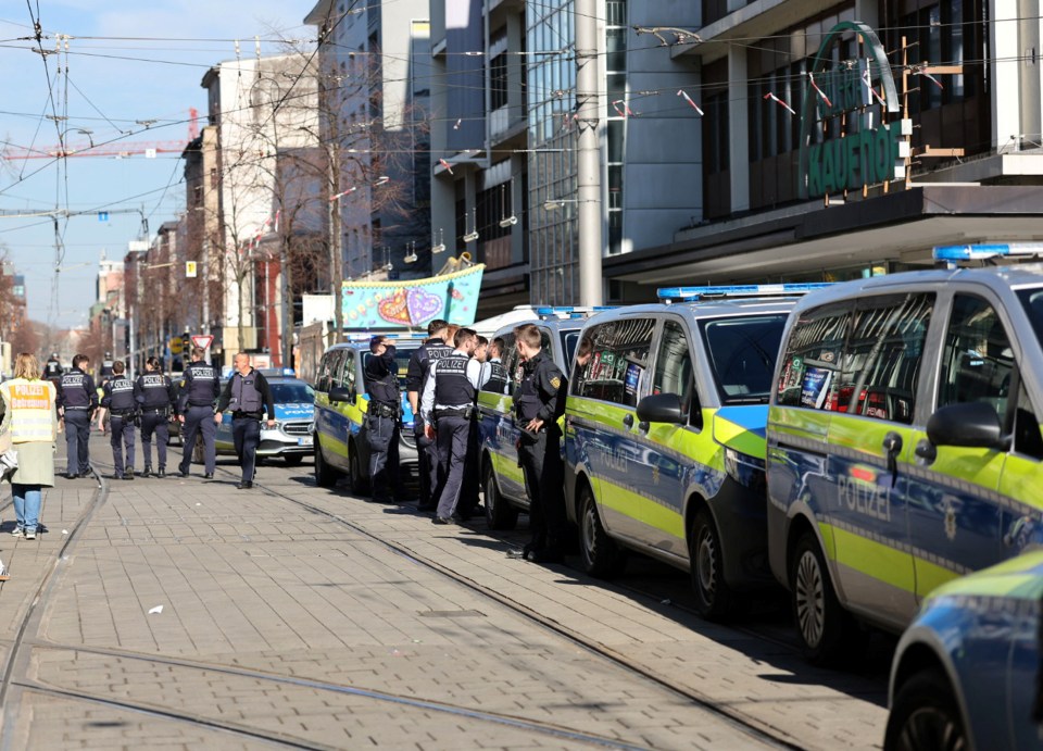 Police officers standing near police cars at a scene.
