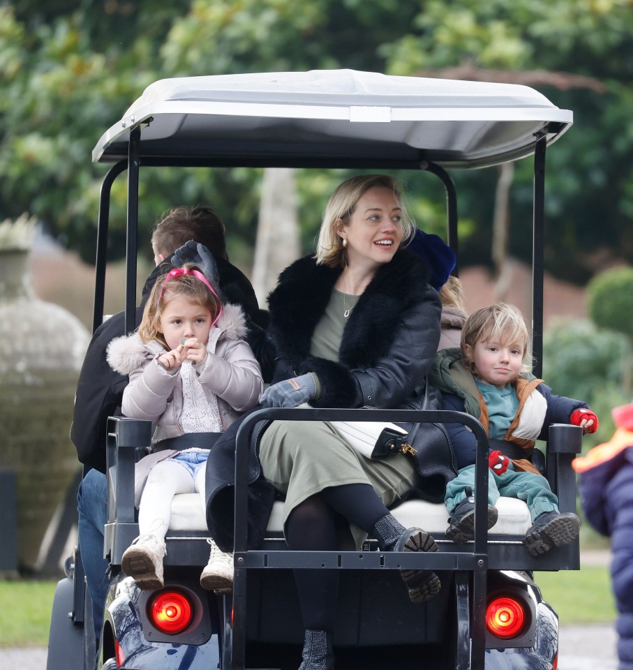 Woman and three children in a golf cart.