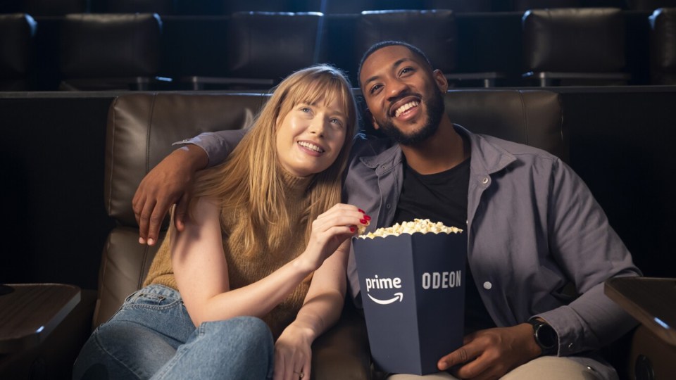 Couple enjoying a movie and popcorn at the Odeon cinema.