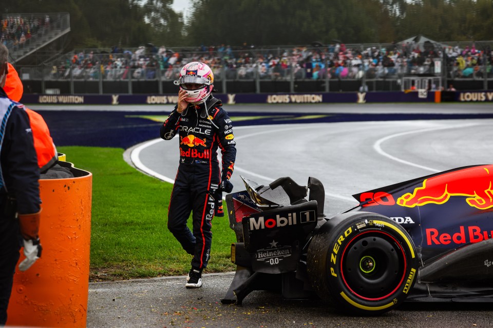 Formula 1 driver Liam Lawson beside his crashed Red Bull Racing RB21 car.