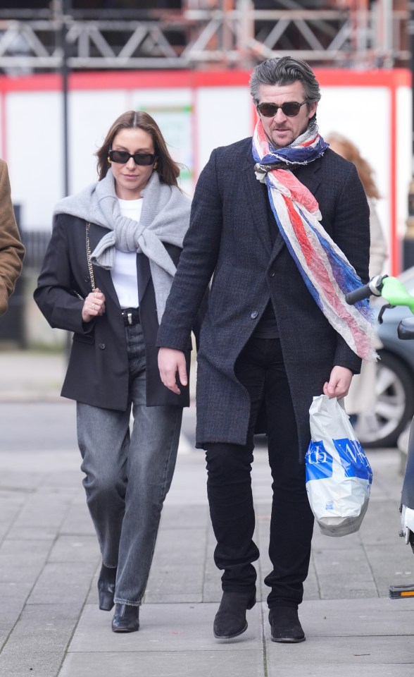 Joey Barton and his wife walking down a sidewalk.