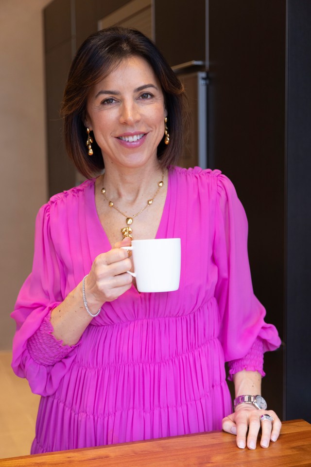 Woman in pink dress holding a mug.