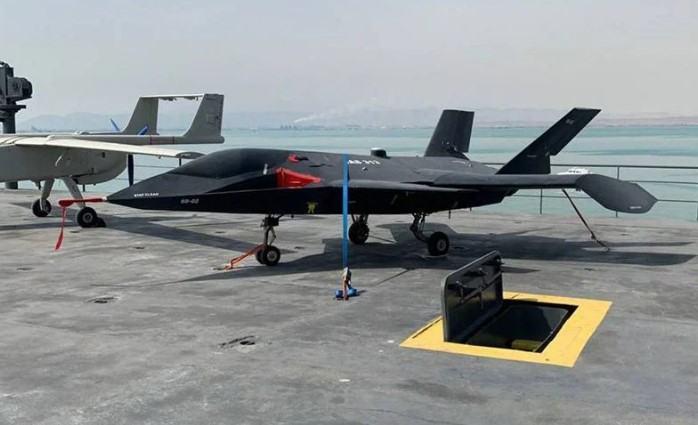 A small, dark-colored stealth fighter jet on a tarmac.
