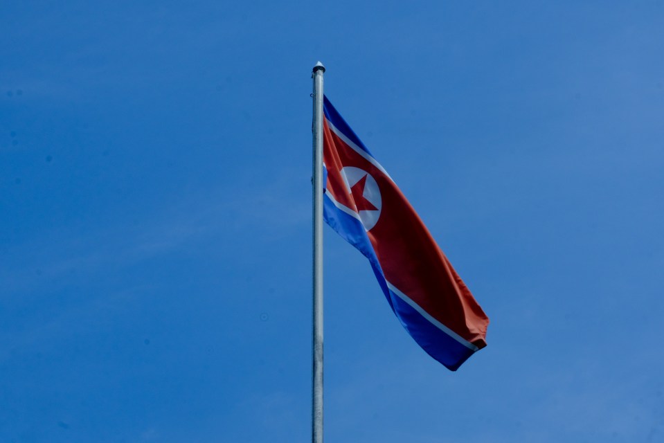 North Korean flag flying against a blue sky.