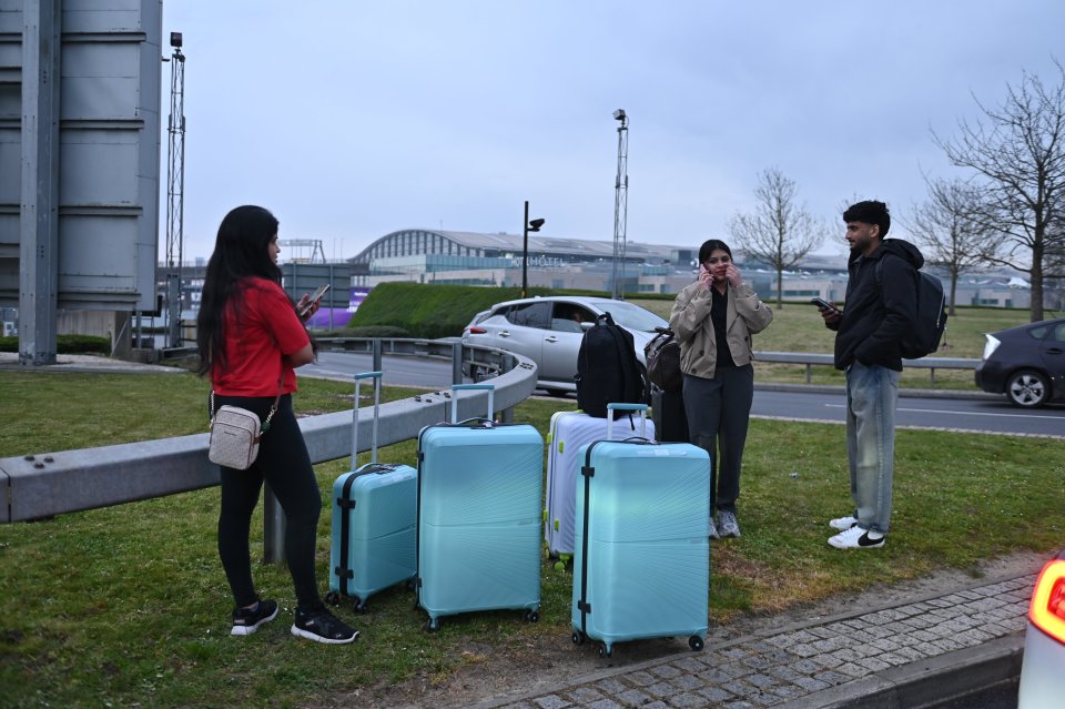 Passengers with luggage outside Heathrow Airport terminal after an electrical fire.