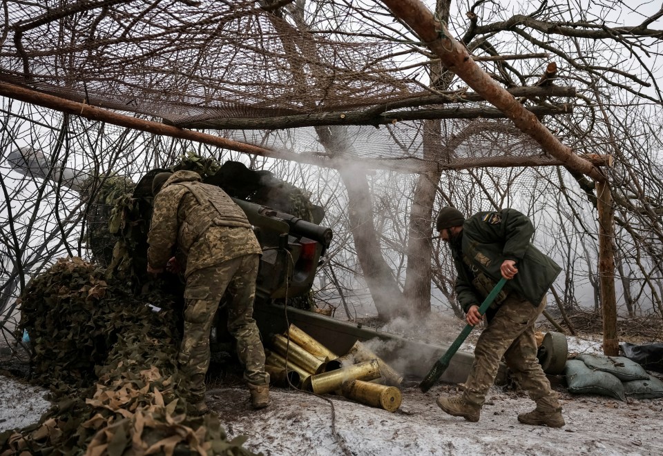 Ukrainian servicemen firing a howitzer.