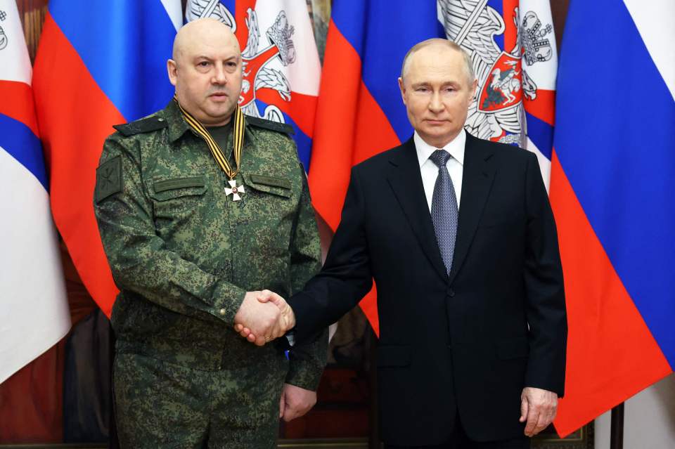 Vladimir Putin shaking hands with General Sergei Surovikin.