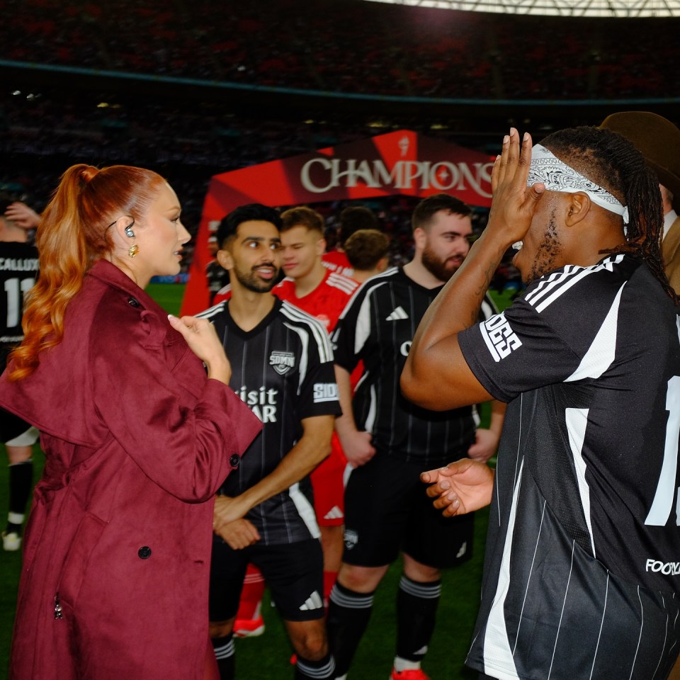 Elz the Witch, presenter at the Sidemen Charity Match, speaking with a soccer player.