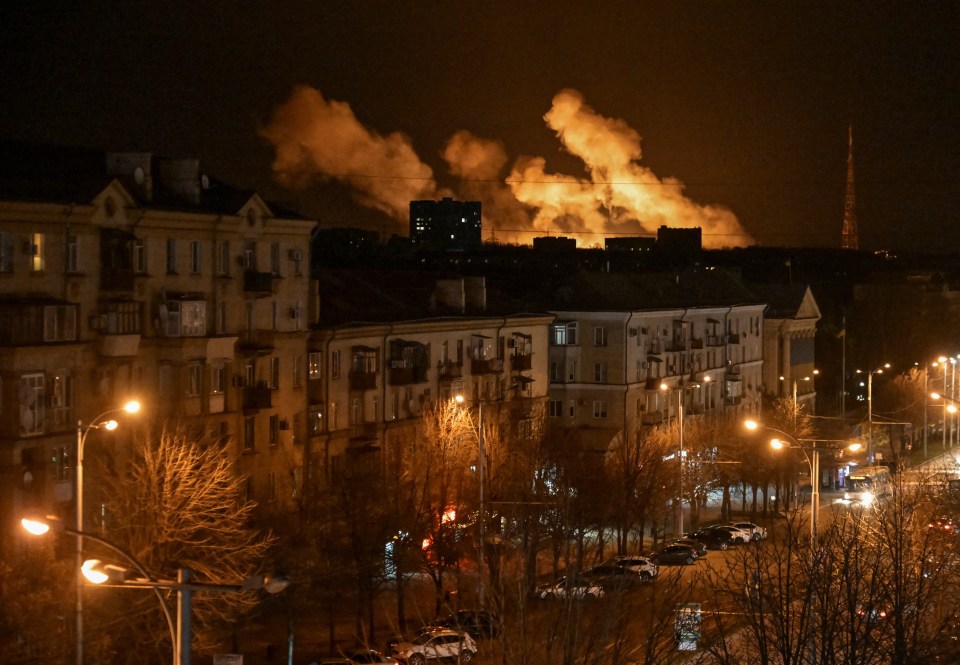 Smoke billows over a city at night after a drone strike.