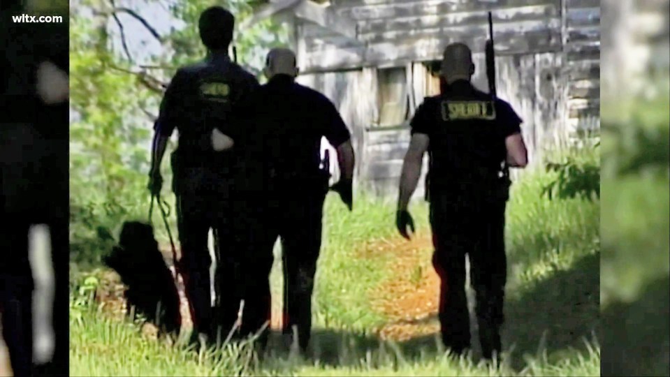 Police officers and a K-9 unit walking near a building.