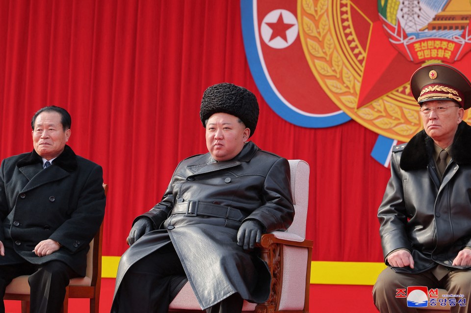 Kim Jong Un seated with two other men.