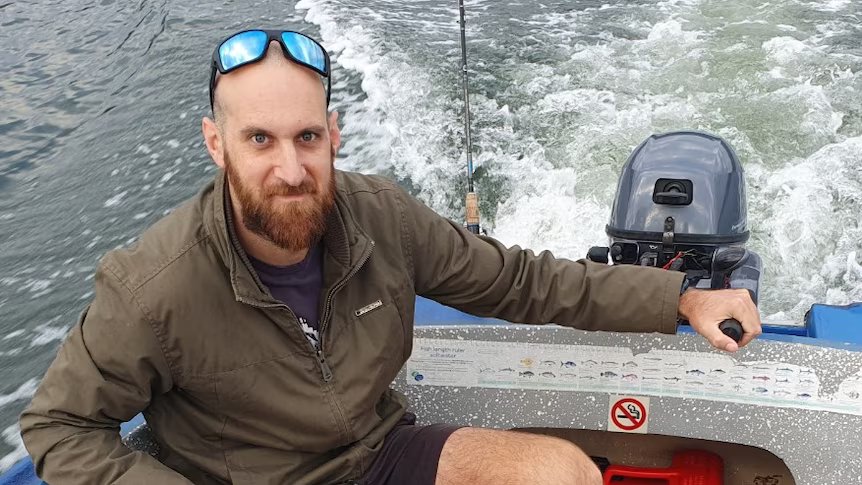Man in a boat holding the throttle.