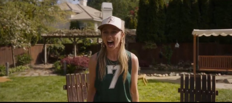 A terrified woman screaming in a backyard.