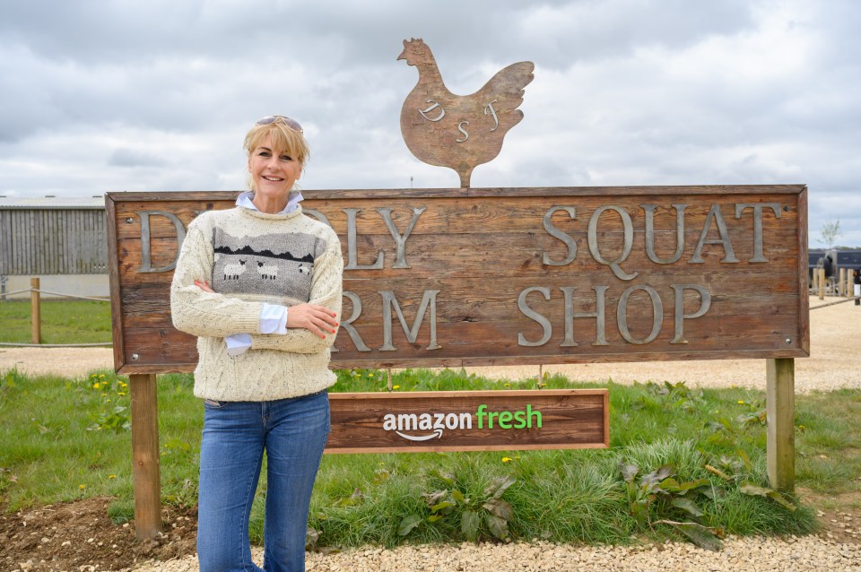 Woman standing in front of Diddly Squat Farm Shop sign with Amazon Fresh logo.