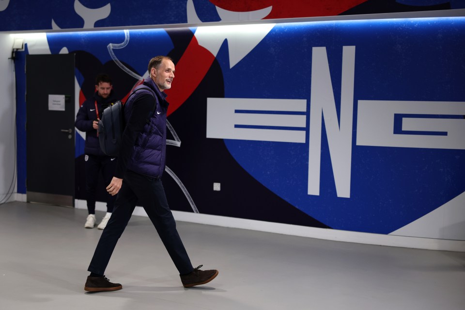 Thomas Tuchel walking in a stadium hallway.