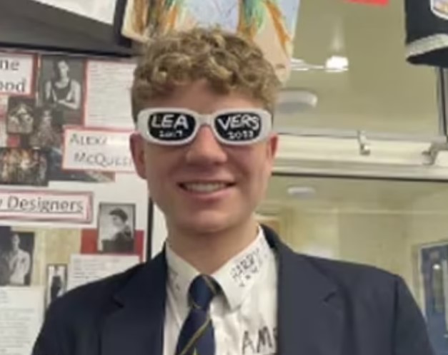 A young man wearing glasses with "Leavers 2023" on them.