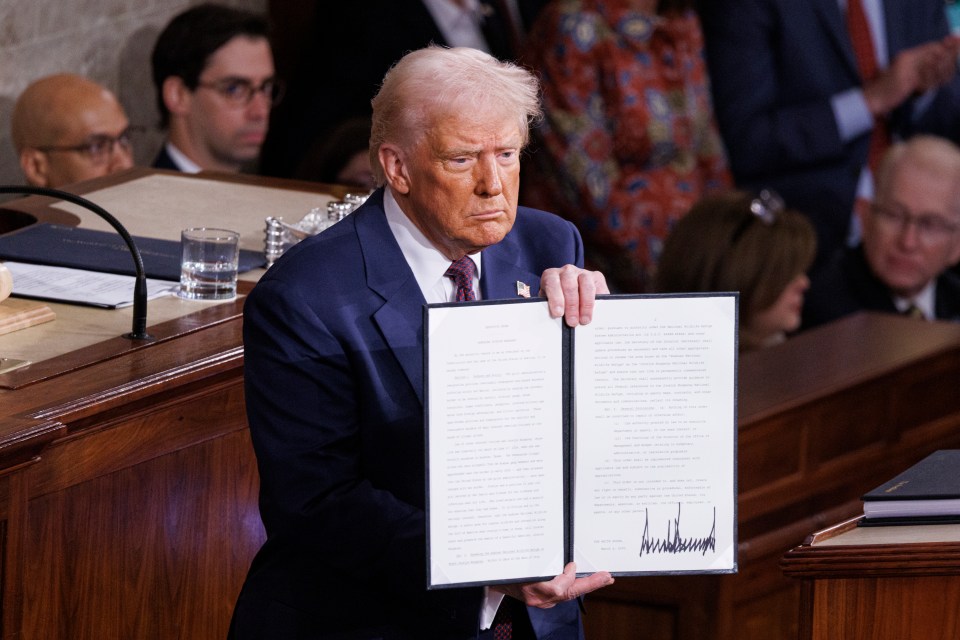 President Trump holding a signed document.