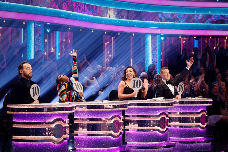 Strictly Come Dancing judges holding up score paddles.