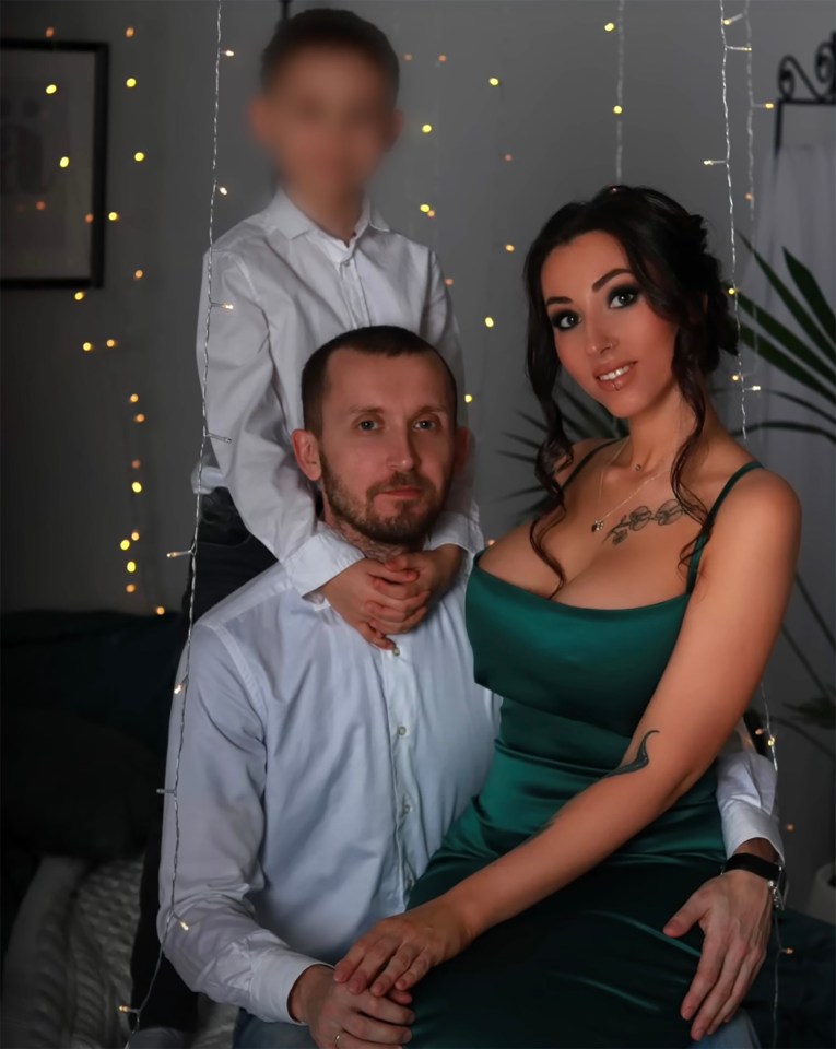 A woman in a green dress sits with her husband and son.