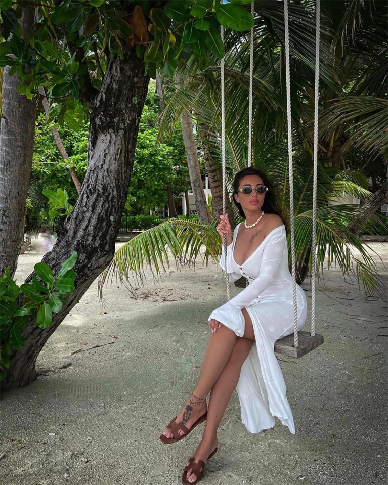 Woman in white dress on a swing in Maldives.