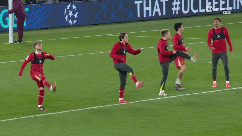 Soccer players warming up on the field.