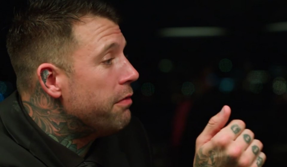 A man with tattoos speaks.