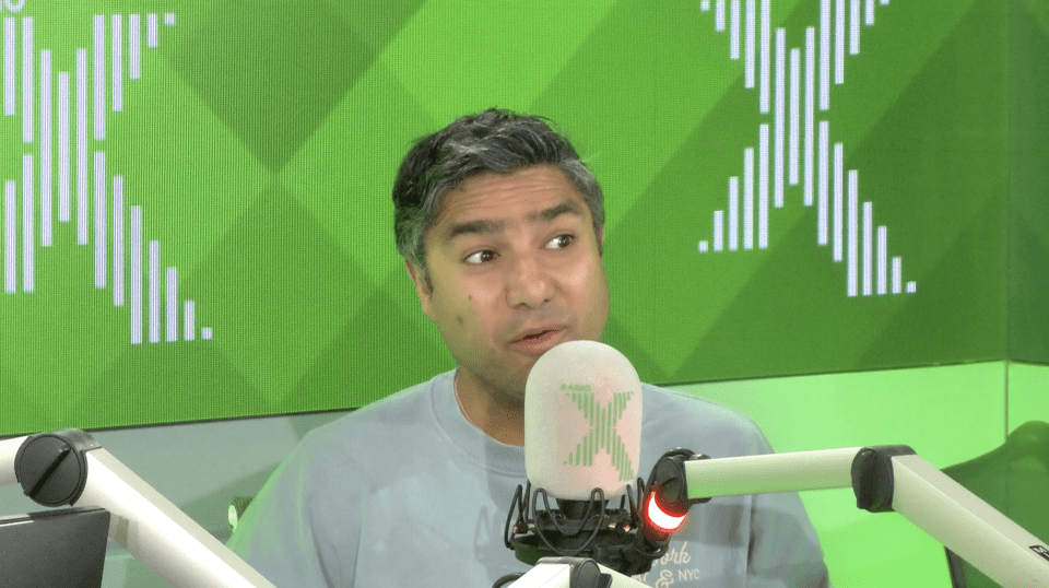 Man speaking into a microphone in a radio studio.