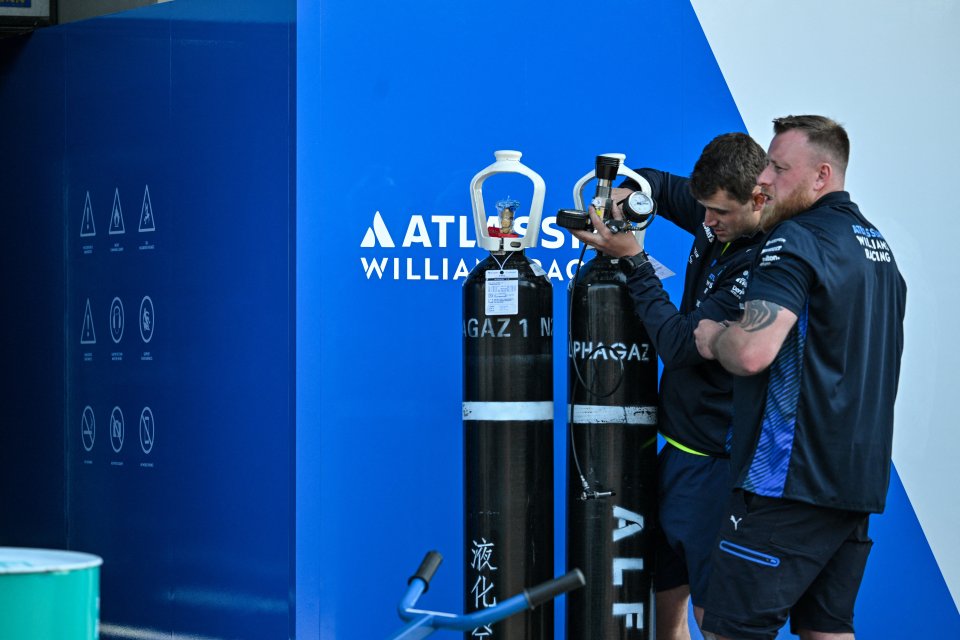 Williams Racing team members checking gas cylinders.