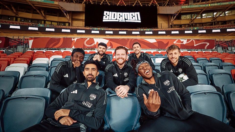 The Sidemen sitting together in stadium seats.