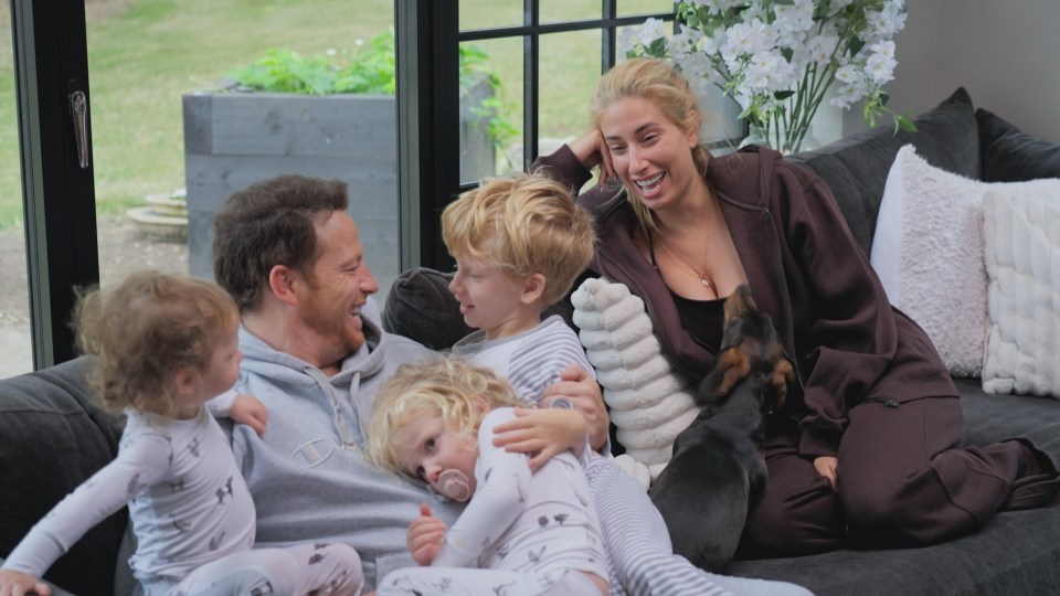 Family relaxing on a couch with their dog.