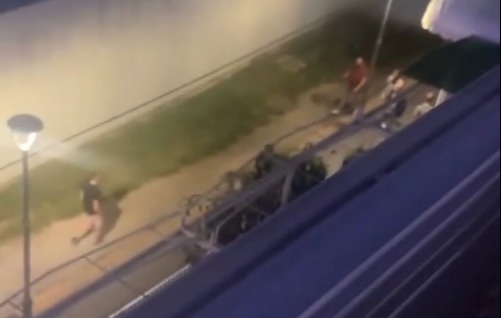 Elevated view of people walking at night near a building.
