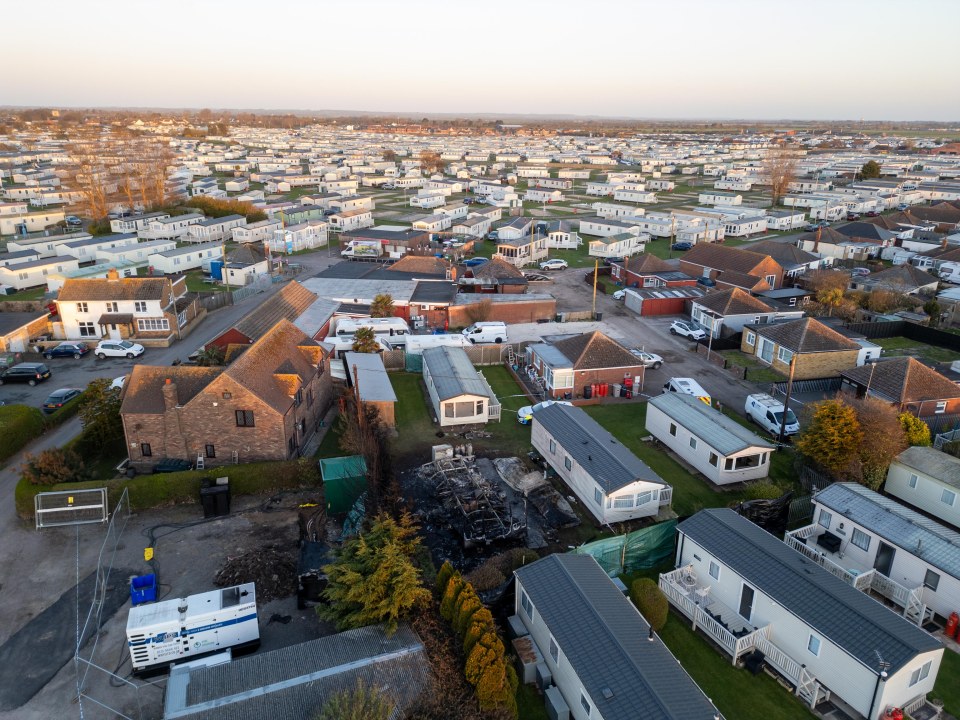 Aerial view of a caravan park with a fire-damaged caravan.