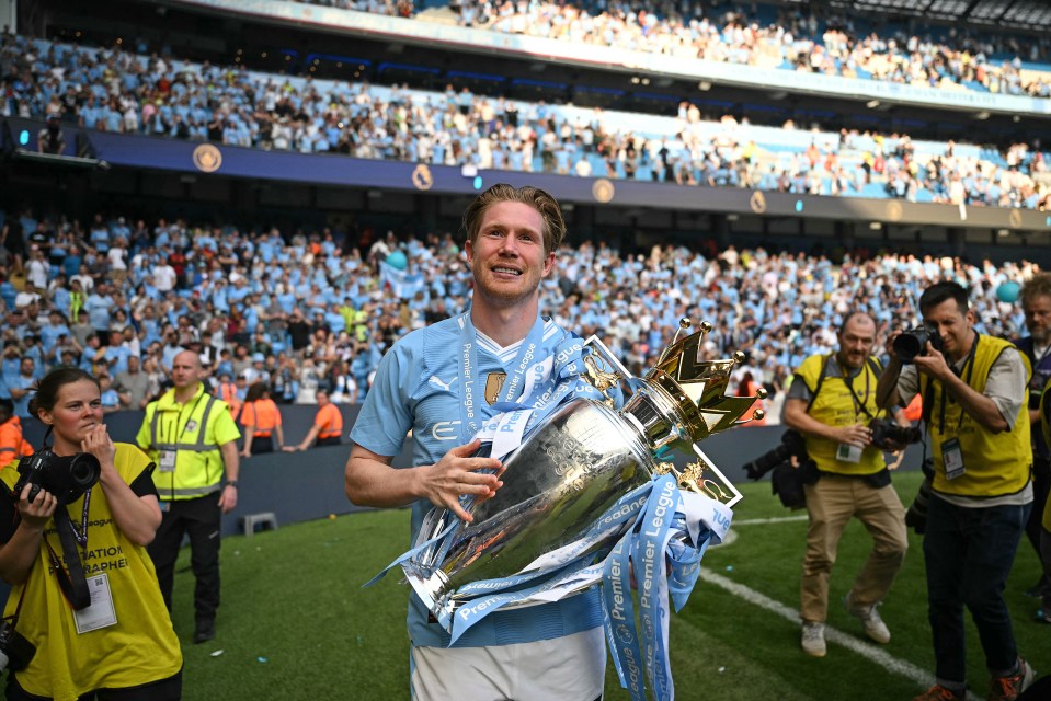 Kevin De Bruyne holding the Premier League trophy.